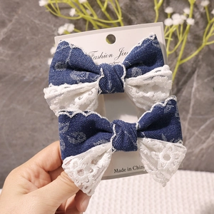 Nahaufnahme von Jeans- und Spitzen-Haarschleifen-Set auf Karte mit Blumenhintergrund