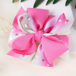 Colorful gradient bow hair clip with silver sequin hearts on a white stone base