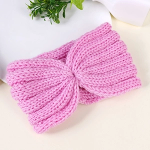 Detailed close-up of pink knitted wide headband with thick ribbed texture and knot detail