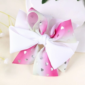 Detail of pink and mint gradient bow hair clip with silver foil heart patterns
