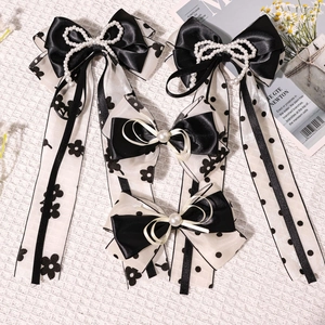 Détail de barrettes à cheveux vintage avec nœuds en maille noir et blanc et perles