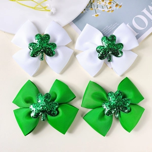 Detail of St. Patrick's Day hair clips with green sequin clovers on striped bow ribbons