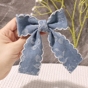 Nahaufnahme der Vintage-Jeans-Haarschleife mit weißer Spitze und floralem Muster