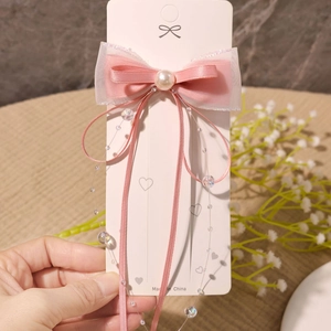 Detail einer rosa Schleifen-Haarspange mit Organza-Schichten und Perlen-Quasten