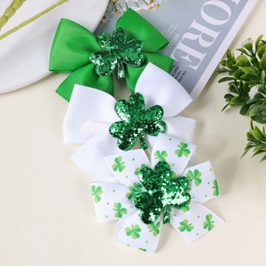 Detailed view of St. Patrick's Day hair bows featuring green clovers and grosgrain texture