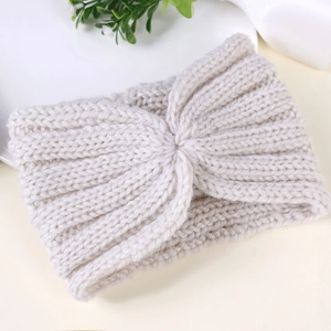 Detail of chunky knit winter headband with twist knot design in cream white color