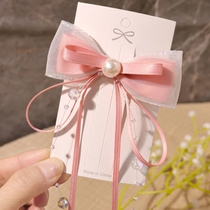 Detail der rosa Schleifen-Haarspange mit Kunstperle, Organza und langen Bandquasten