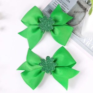 Close-up of green grosgrain ribbon hair bows with glitter shamrocks for St. Patrick's Day