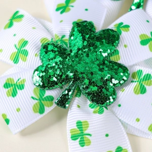 Macro view of St. Patrick's Day hair bow with green sequin clover and white ribbon