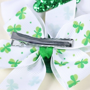 Detail view of the silver alligator clip and clover pattern ribbon on the bow hair clip