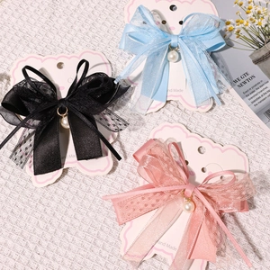 Detail showing lace bow hair clips with pearls in black blue and pink colors