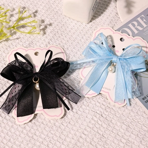 Detail of lace bow hair clips with white pearl charms on decorative handmade cards