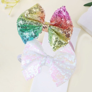 Dettaglio di due cerchietti con fiocchi di paillettes in arcobaleno e bianco lucido