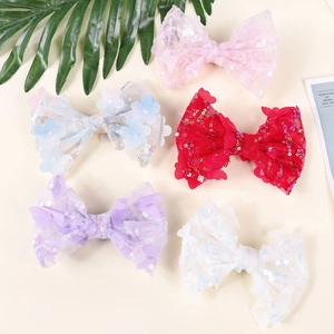 Detail showing lace bow hair clips with colorful sequins and butterfly fabric patches
