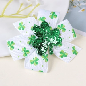 Detail of St. Patrick’s Day hair bow featuring green clovers and sparkling glitter shamrock