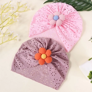 Close-up of soft breathable hollow out knit baby hats with 3D floral accents in pink and purple