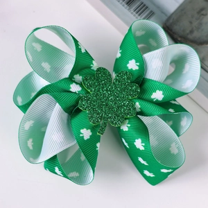 Close-up of Saint Patrick's Day green clover bow clip with white shamrock pattern