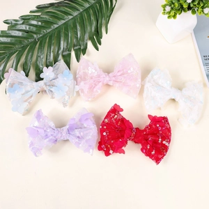 Close-up of five handmade sequin lace bow hair clips in assorted pastel colors for girls
