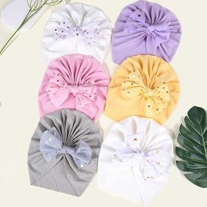 Flache Ansicht von sechs Baby-Turban-Mützen mit gepunkteten Schleifen in Pastellfarben