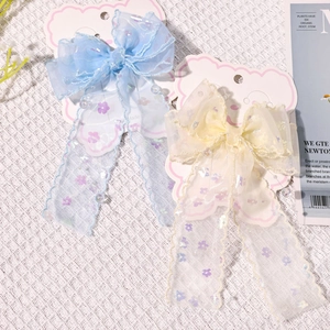 Detailansicht von zwei Organza-Haarspangen mit Blumenmuster und Perlenakzenten