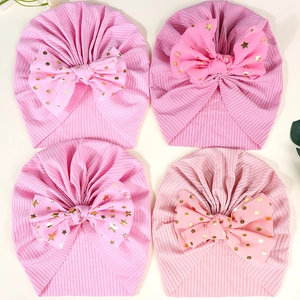 Detailansicht von vier rosa Baby-Turbanen mit großen goldenen Pailletten-Schleifen