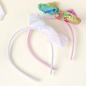 Dettagli di fiocchi con paillettes fatti a mano su cerchietti colorati per capelli bimba