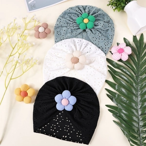 Detail of baby bohemian mesh hats with floral accents in blue, beige and black