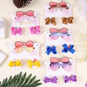 Detailed set of kids gradient heart sunglasses and ribbon bow hair clips on pink card