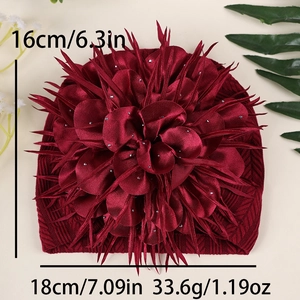 Detail eines Baby-Turban-Huts in Dunkelrot mit großer 3D-Blume und Silberperlen