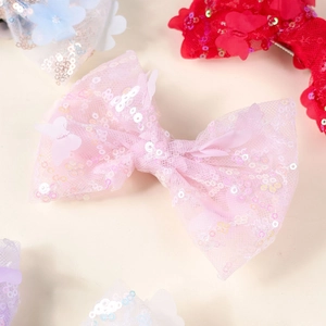 Close-up of colorful sequin bow hair clips for girls in pink, red, blue, and purple