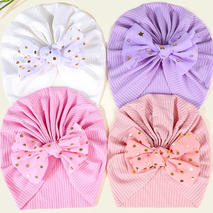 Detailansicht von vier elastischen Nylon-Babymützen mit Schleifen in Weiß und Rosa