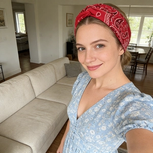 Gros plan du bandeau à nœud cachemire rouge porté avec une robe d'été à fleurs bleu clair
