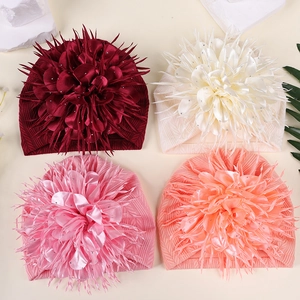 Detailansicht von vier Baby-Turban-Hüten mit großen Camellia-Blumen und Strickgewebe