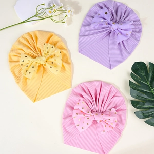 Detailansicht von Baby-Turban-Mützen mit funkelnden Paillettenschleifen in Pastellfarben