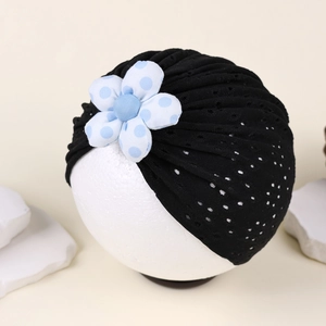 Detailed close-up of breathable hollow knit baby turban hat with blue polka dot flower