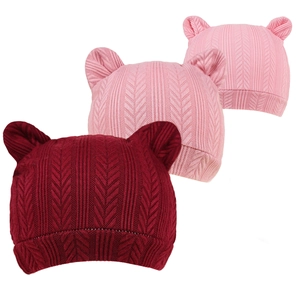 Détail de trois bonnets tricotés pour nouveau-nés avec oreilles d'ours et chevrons