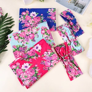 Détail de couverture d'emmaillotage pour bébé et bandeau assorti à fleurs en 3 tons