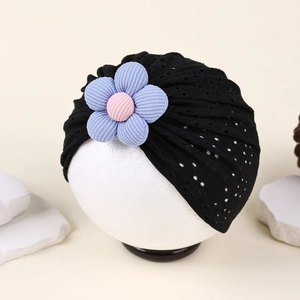 Detail of baby turban featuring black hollow mesh fabric and 3D floral decoration