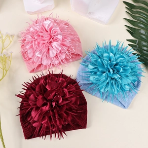 Detailansicht von Baby-Turban-Mützen mit großen Stoffblumen in Rosa und Blau