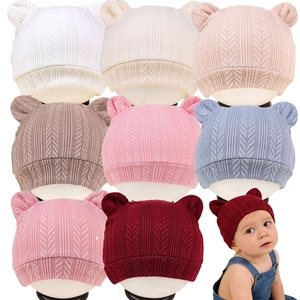 Vue détaillée de bonnets tricotés pour bébé aux oreilles d'ours et motifs texturés