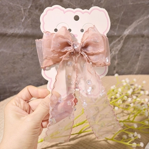 Detail der rosa Organza-Schleife mit Pailletten und Perlenquasten auf der Displaykarte
