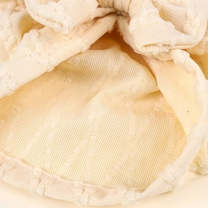 Détail macro de la texture tricotée crème douce et maille pop-corn pour bonnet de bébé