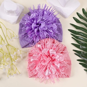 Detailansicht der Baby-Turbanmützen mit großen Strass-Kamelienblüten in Lila und Rosa