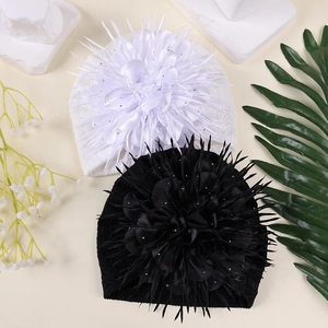 Detailansicht einer übergroßen Kamelienblüte auf einer Baby-Turbanmütze mit Strasssteinen