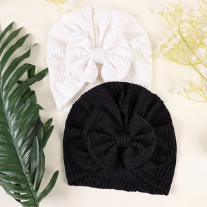Detail of newborn ribbed bow hats in black and white with subtle jacquard patterns