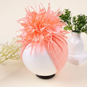 Detail einer rosa Strickmütze für Babys mit einer großen Kamelie und Strasssteinen