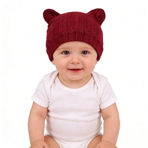 Gros plan d'un bonnet tricoté bordeaux pour bébé avec des oreilles d'ours mignonnes