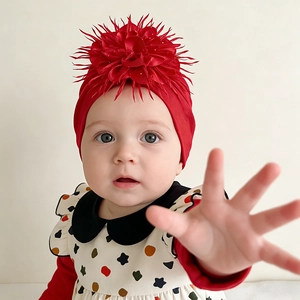 Detail of red baby turban hat with a large 3D flower decoration and soft cotton fabric