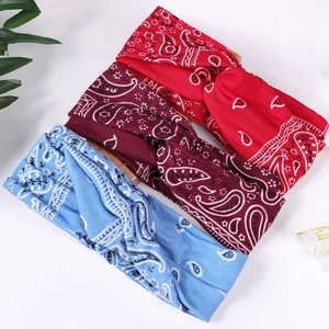 Vue détaillée de bandeaux paisley torsadés rouges et bleus sur un support en bois