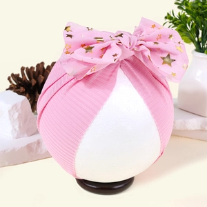 Detail der Baby-Turbanmütze in Rosa mit großer Tüllschleife und goldenen Sternen